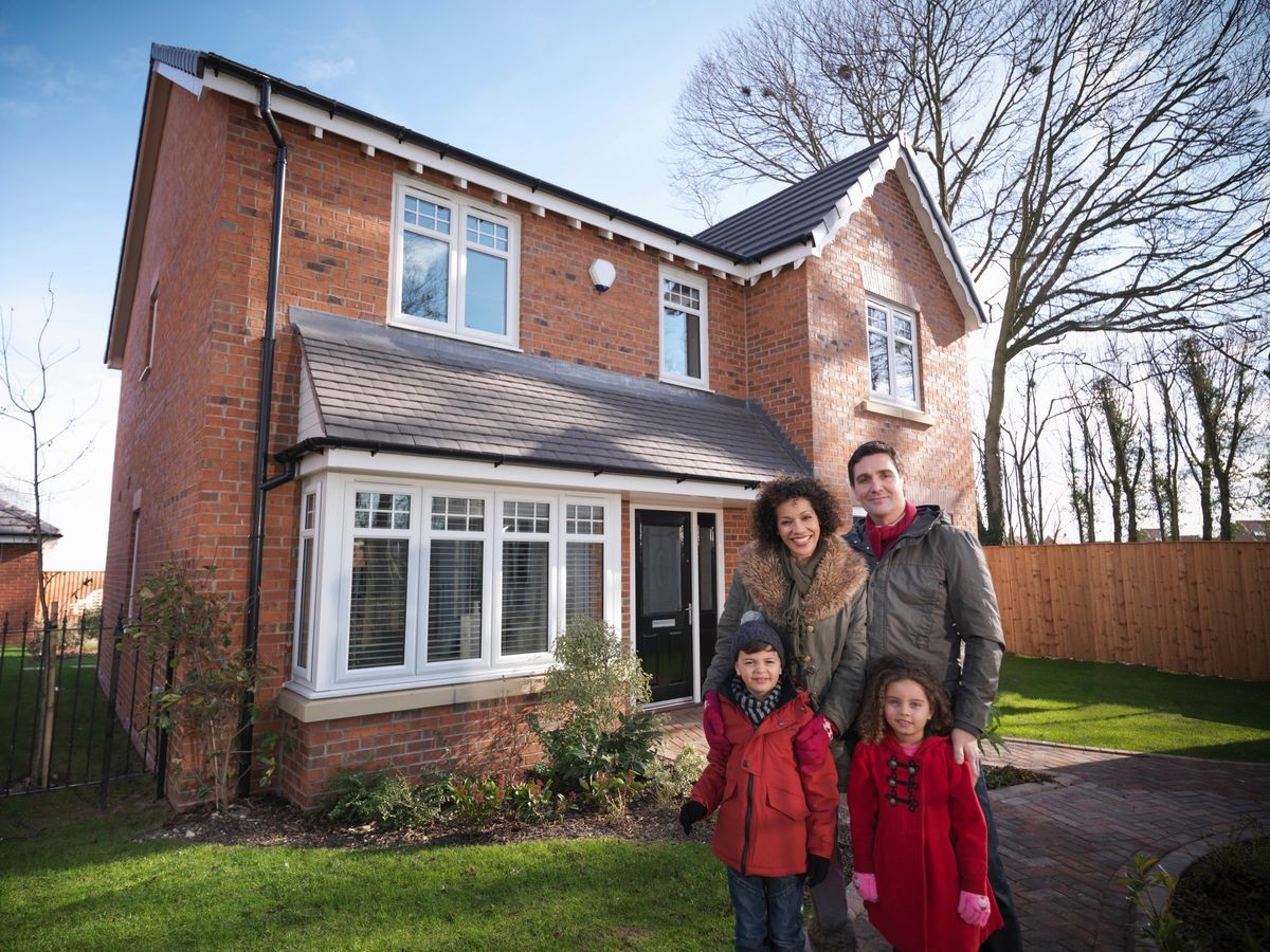 Family standing outside of energy efficient house